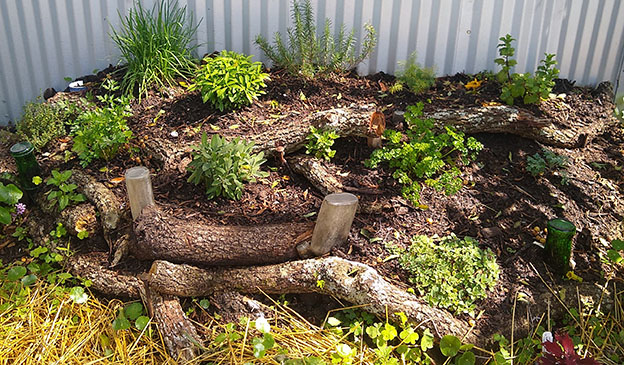 Pictured: an herb garden bed built with small logs